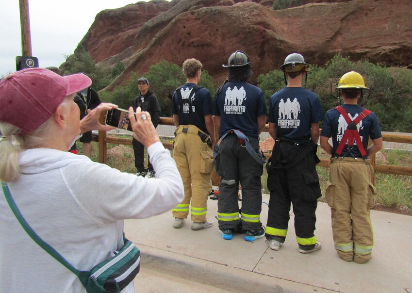 A parent takes a photo of four members of the Warren Tech Fire Academy class taking part in the stair climb.